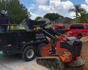 Workers from Daniels Landscaping & Irrigation LLC operating a Ditch Witch