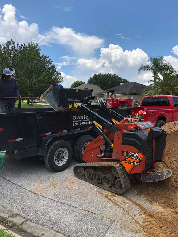 Workers from Daniels Landscaping & Irrigation LLC operating a Ditch Witch