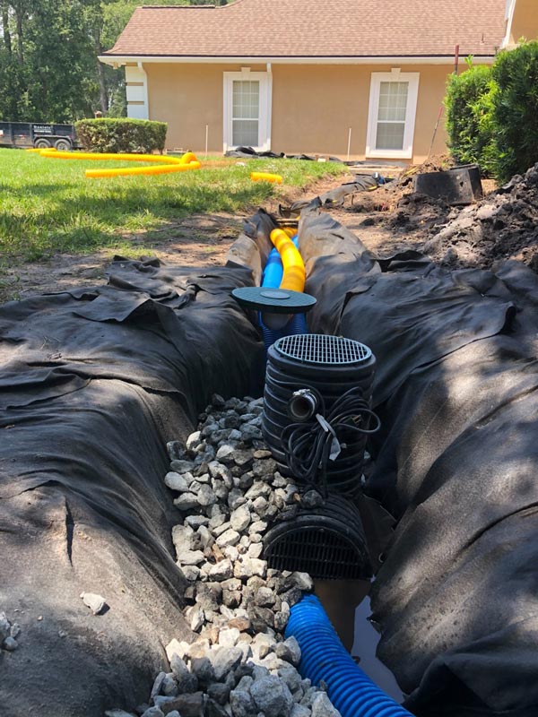 Covering a French drain system with rocks