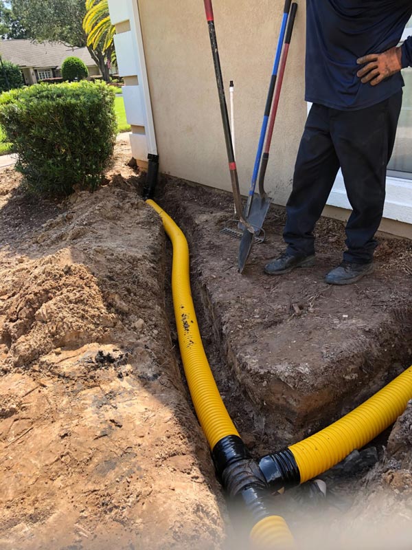 A Daniels Landscape & Irrigation LLC worker standing by a freshly installed French drainage system