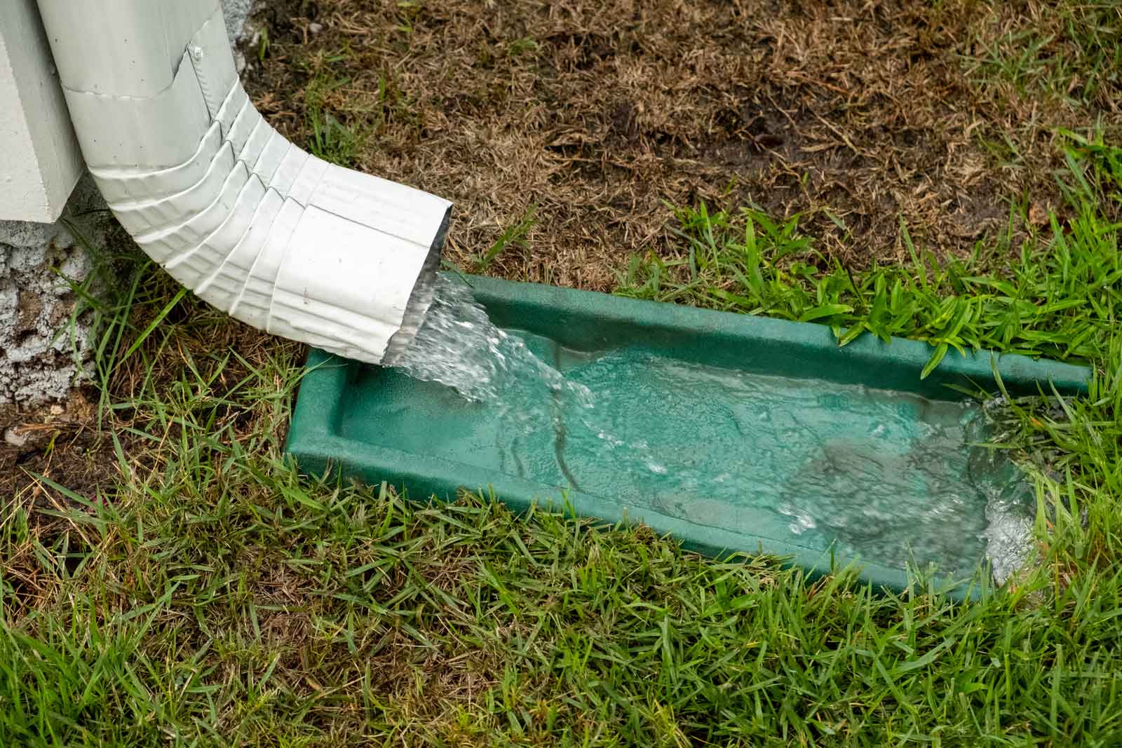 Water rushing down a gutter downspout during a severe rainstorm